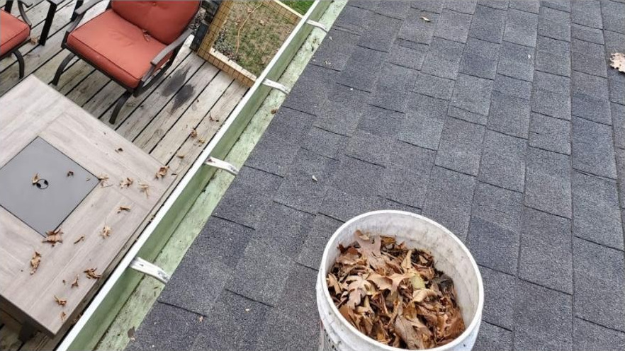 Gutter line cleared by hand with debris bucketed on a Rochester roof